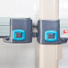 A close-up of two blue and gray plastic clips on a metal MetroMax Q shelving unit.
