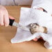 A person using a Choice Boston Style Oyster Knife with a black handle to cut an oyster.