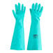 A pair of green unlined rubber gloves with a label.