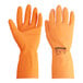 A close-up of a pair of orange Cordova rubber gloves with flock lining.