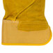 A close up of a Cordova yellow canvas work glove with russet leather palm coating and rubber cuffs.