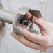 A hand holding a metal seal ring for an AvaMix immersion blender.