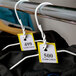 A white wire rack with yellow Choice paper coat check tickets on it.