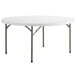 A white round Lancaster Table & Seating folding table with metal legs.