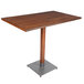 A Lancaster Table & Seating bar height table with a live edge walnut top and metal base.