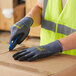 A person wearing Cordova ActivGrip Advance safety gloves holding a box.