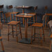 A Lancaster Table & Seating bar height table with wooden stools.