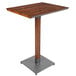 A Lancaster Table & Seating bar height table with a wood top and metal base.