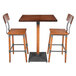 A Lancaster Table & Seating live edge wood bar table with two bar chairs.