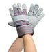 A pair of Cordova warehouse gloves with blue and gray stripes on the cuffs.