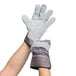 A pair of hands wearing Cordova striped canvas work gloves with leather palms.