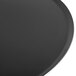 A close-up of a Matfer Bourgeat black carbon steel round pizza pan.