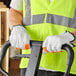A man wearing Cordova warehouse gloves with hi-vis fingertips holding a tool.