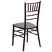 A Flash Furniture walnut chiavari stacking chair with a wooden back and black seat.