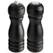 Two black wooden pepper mills with black and silver tops and a black wooden salt shaker.