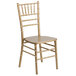 A gold Flash Furniture Hercules Chiavari stacking chair with a wooden seat.
