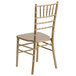 A gold Flash Furniture Hercules Chiavari stacking chair with a white background.
