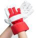 A pair of Cordova red canvas work gloves with rubber cuffs on a person's hands.