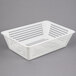 A white plastic basket with holes inside a Campus Products CDM-STAR Silvershine cutlery dryer.