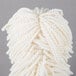 A close-up of a white yarn mop head.