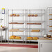A chrome Regency stationary metal shelving rack with bread on it.