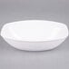 A white Fineline oval Luau bowl on a gray surface.