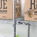 A Metro Super Erecta wire shelving unit with boxes on a shelf.
