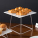 A stainless steel Acopa display stand with a plate of croissants on it.