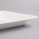A close-up of a white Fineline square catering tray.
