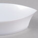 A white Fineline Tiny Treasures plastic tray with curved edges on a gray surface.