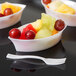 A white plastic tray with fruit in it.