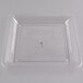 A clear plastic square catering tray with a small square pattern in the center.