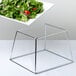 A plate of salad on a Acopa stainless steel square display stand.