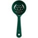 A close-up of a Carlisle green plastic perforated portion spoon with a short handle.