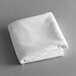 A folded white Intedge cloth table cover on a gray surface.