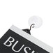 A close-up of a black plastic business hours sign with white lettering on a hook.
