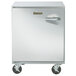 A Traulsen stainless steel undercounter freezer with wheels and a left hinged door.