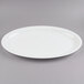 A white plastic oval Fineline Cater Tray with a rim.