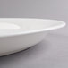 A white plastic oval Fineline Cater Tray with a rim.