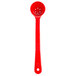 A red Carlisle long handled portion spoon with perforations.