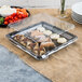 A Fineline black plastic square cater tray with food on it.