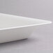 A close-up of a Fineline white plastic square catering tray with a small edge.
