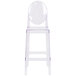 A clear plastic chair with a clear plastic oval back.
