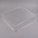 A clear plastic container with a Fineline clear plastic square dome lid on top.
