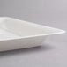 A close-up of a Fineline white plastic square catering tray with a lid on it.