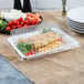 A Fineline white plastic rectangular cater tray with food inside.