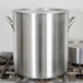A Vollrath stainless steel cover on a large silver pot.