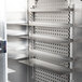 A Continental reach-in refrigerator with a stainless steel half glass door and shelves with metal racks.