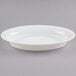 A white Fineline oval catering bowl with a rim.