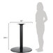 A woman standing next to a BFM Seating black round counter height table with a round base.